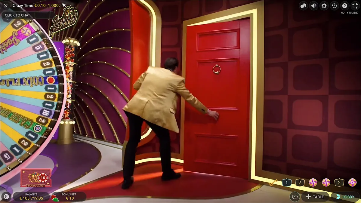 Il conduttore di Crazy Time apre una porta rossa dello studio accanto alla ruota