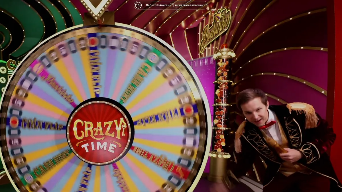 Il conduttore di Crazy Time accanto alla ruota verticale